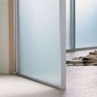 Particolare porta vetro alluminio battente Mitika stipite con coprifilo rovere-1500 Particolare porta vetro alluminio battente Mitika stipite con coprifilo rovere-1500